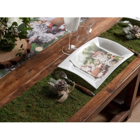 Présentation des assiettes et couverts sur le chemin de table végétal sur une table bois naturel